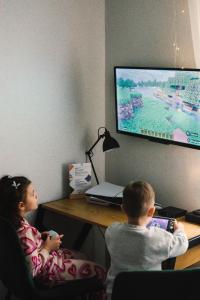 a boy and a girl playing a video game at Ajncla in Katowice