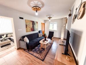 a living room with a couch and a tv at Grmec Cabin Rental in Podgradina