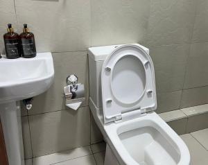 a bathroom with a white toilet and a sink at Serenity Residences Studio Ruaka Near Two Rivers & UN Gigiri in Ruaka +16 photos