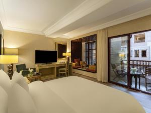 a hotel room with a bed and a television at Mövenpick Resort Petra in Wadi Musa