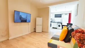 a living room with a flat screen tv on a wall at Apple Garden A-2 in London