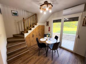 a dining room with a table and chairs and a staircase at Grmec Cabin Rental in Podgradina +49 photos