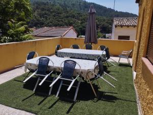 a table and chairs and an umbrella on a lawn at Casa Rural Las Mieles in Chillarón del Rey