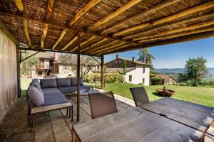 a patio with a couch and a table and chairs at Appartamento Gemma Bianca-tavoleto in Castiglione dʼOrcia
