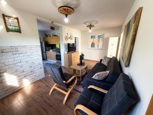 a living room with a couch and two chairs at Grmec Cabin Rental in Podgradina
