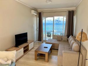 a living room with a couch and a tv at IONIAN MARE in Agios Ioannis Peristerion