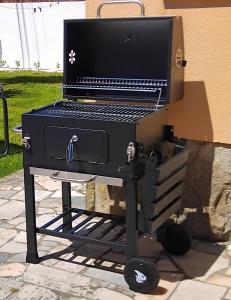 a barbecue grill sitting on a cart on a patio at Beach house with garden in Sintra