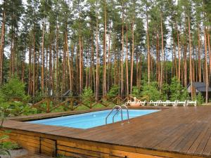 a swimming pool on a wooden deck with trees in the background at Царів Хутір in Tsarivka