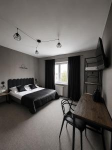 a bedroom with a bed and a wooden table at Pensjonat Kocius in Rewal