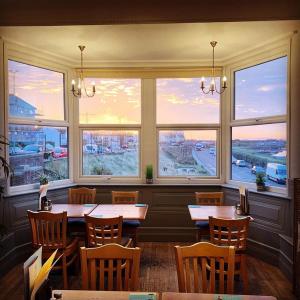 a restaurant with tables and chairs and large windows at The Gather Inn in Brighton & Hove