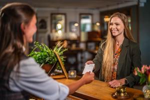 a woman sitting at a bar talking to a customer at Steningevik in Märsta