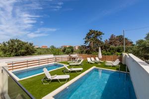 a swimming pool on the roof of a building with lounge chairs at Casa Eda in Agia Marina Nea Kydonias