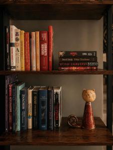 a book shelf with books and a vase on it at Pensjonat Kocius in Rewal