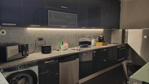 a kitchen with a sink and a washing machine at Casa Valadim in Chaves