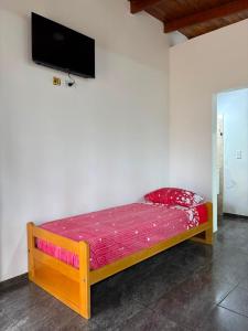 a wooden bed in a room with a tv on the wall at Dos Osos in Villa General Belgrano