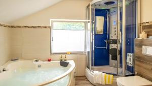 a large bathroom with a tub and a shower at Exclusiv Apartment - Seepanorama in Schalkenmehren +8 photos