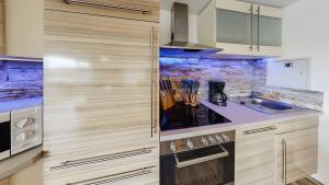 a kitchen with wooden cabinets and a counter top at Exclusiv Apartment - Seepanorama in Schalkenmehren