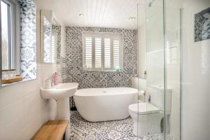a bathroom with a tub and a sink and a toilet at 2 Bed in Mumbles oc-t42823 in The Mumbles +22 photos