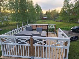 a wooden deck with a table and a fence at Villa Sysslebäck Branäs Långberget in Sysslebäck