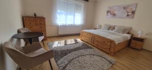 a bedroom with a bed and a table and a chair at Akácfa Vendégház in Makó