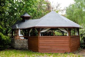 a wooden gazebo with a black roof at Ajncla in Katowice