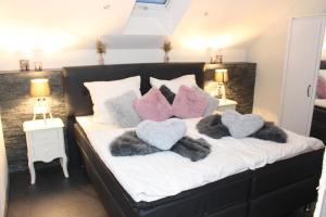 a bed with four pillows on it with three hearts at Eifel Dream Ardennenblick in Kobscheid
