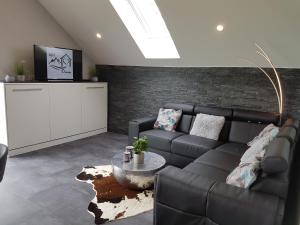 a living room with a couch and a table at Eifel Dream Ardennenblick in Kobscheid