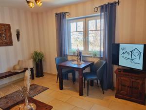 a living room with a table and a tv at Eifel Dream Kleinenims in Burbach
