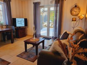 a living room with a couch and a tv and a table at Eifel Dream Kleinenims in Burbach