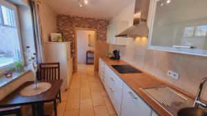 a kitchen with white cabinets and a table in it at Eifel Dream Kleinenims in Burbach +7 photos