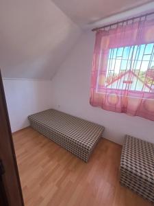 a room with two beds and a window at Stella apartman in Gabčíkovo
