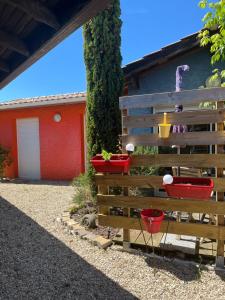 a wooden fence with three plants in red buckets at La maison du bonheur in Audenge