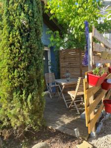 a wooden deck with a table and a bench at La maison du bonheur in Audenge +2 photos