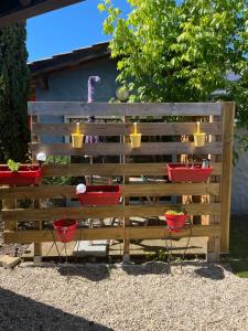a wooden fence with four red chairs and candles at La maison du bonheur in Audenge