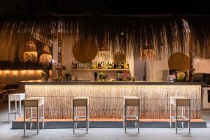 a bar with three stools in front of a counter at Hotel Chevy & Suites in Cala Ratjada