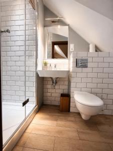 a bathroom with a toilet and a sink and a shower at Pensjonat Kocius in Rewal