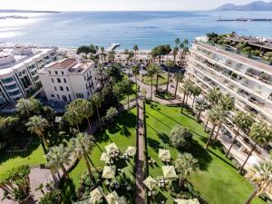 an aerial view of a park with palm trees and buildings at Mondrian Cannes in Cannes