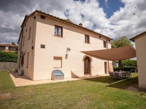 a large white house with a large tent in the yard at Private Villa San Luigi in Sarteano