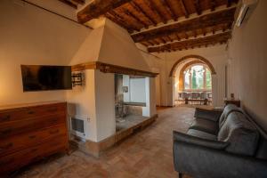 a living room with a couch and a fireplace at Private Villa San Luigi in Sarteano