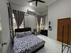 a bedroom with a bed and a ceiling fan at D Teratak Homestay in Marang