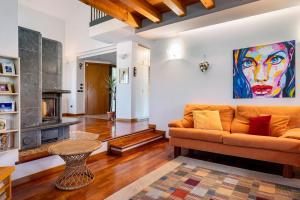 a living room with a couch and a painting on the wall at La Casa di Gio - 2 Camere Singole in Campanella