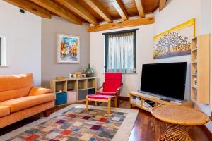 a living room with a couch and a television at La Casa di Gio - 2 Camere Singole in Campanella