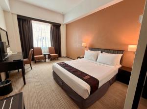 a hotel room with a bed and a desk at Hotel Seri Malaysia Lawas in Lawas
