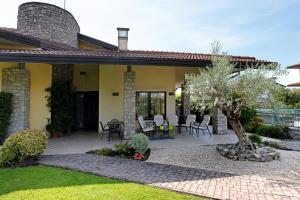 a house with a patio with chairs and a tree at La Casa di Gio - 2 Camere Singole in Campanella