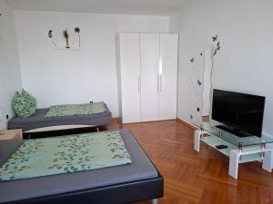 a living room with two beds and a flat screen tv at Ferienhaus Savannah in Schützen am Gebirge