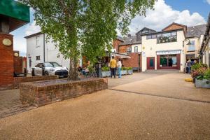 a street with a tree in a brick wall at Stoops Hall - 2 bed first floor apartment in Garstang