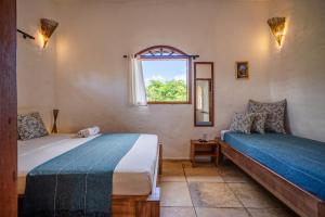 a bedroom with two beds and a window at Villa Medina Oasis in Jericoacoara