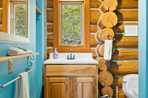 a bathroom with a sink and a wooden wall at Viewtopia in Suttons Bay +30 photos