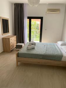 a bedroom with a bed with two stuffed animals on it at Villa Loukas in Loutsa