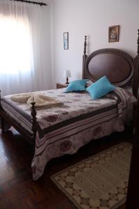a bedroom with a large bed with blue pillows at Vivenda Atlantico in Vila Praia de Âncora